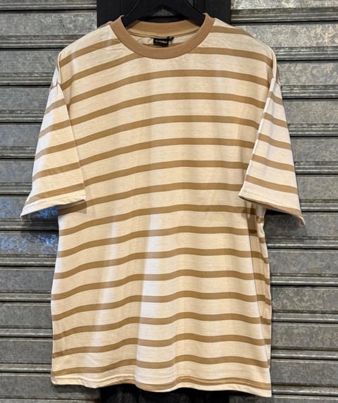 Remera a rayas beige y blanca en percha