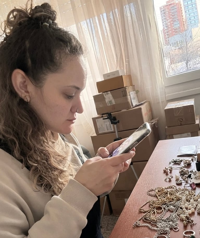 Emprendedora mirando su celular en su espacio de trabajo con joyería y cajas de envío