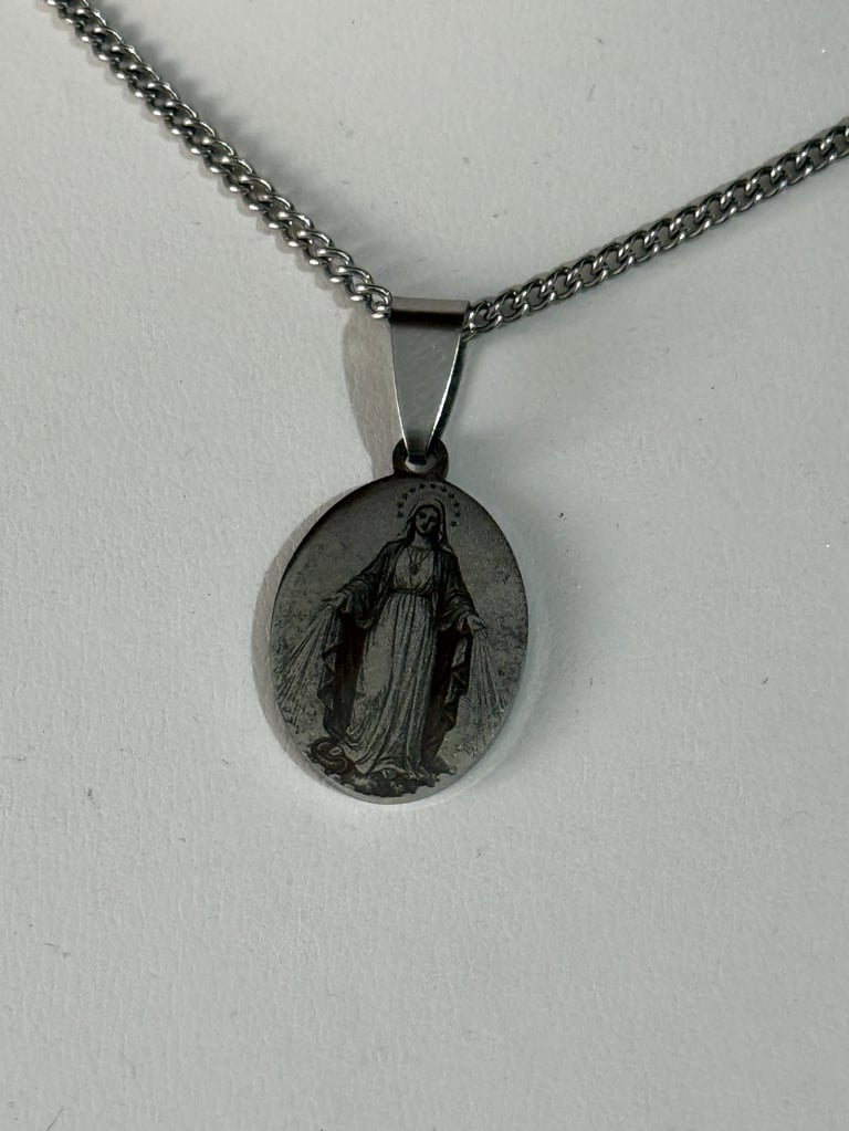 Silver religious medal pendant on chain featuring Virgin Mary