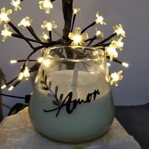 White frosted vase with calligraphy text containing warm white flower-shaped LED lights on black branches