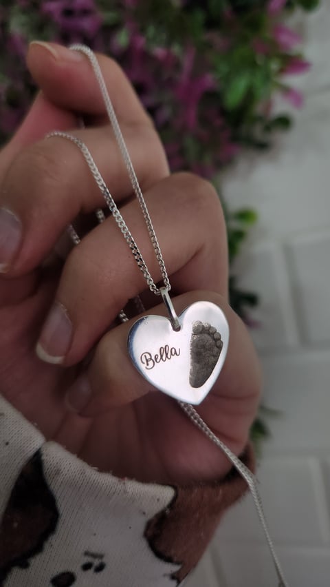 Collar de corazón Bella en mano sin iluminación profesional