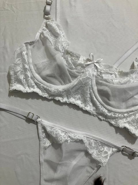 Conjunto de lencería blanca colgado en tendedero